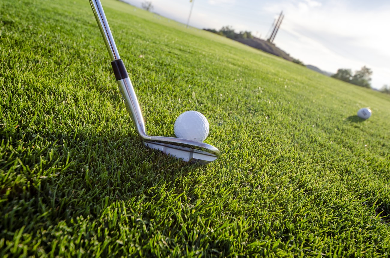 Eisen und Golfball im Moment vor dem Schlag auf der Driving Range